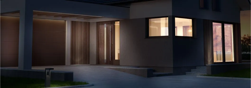 Moderne woning in de avond met houtlook voordeur en ruime raamkozijnen